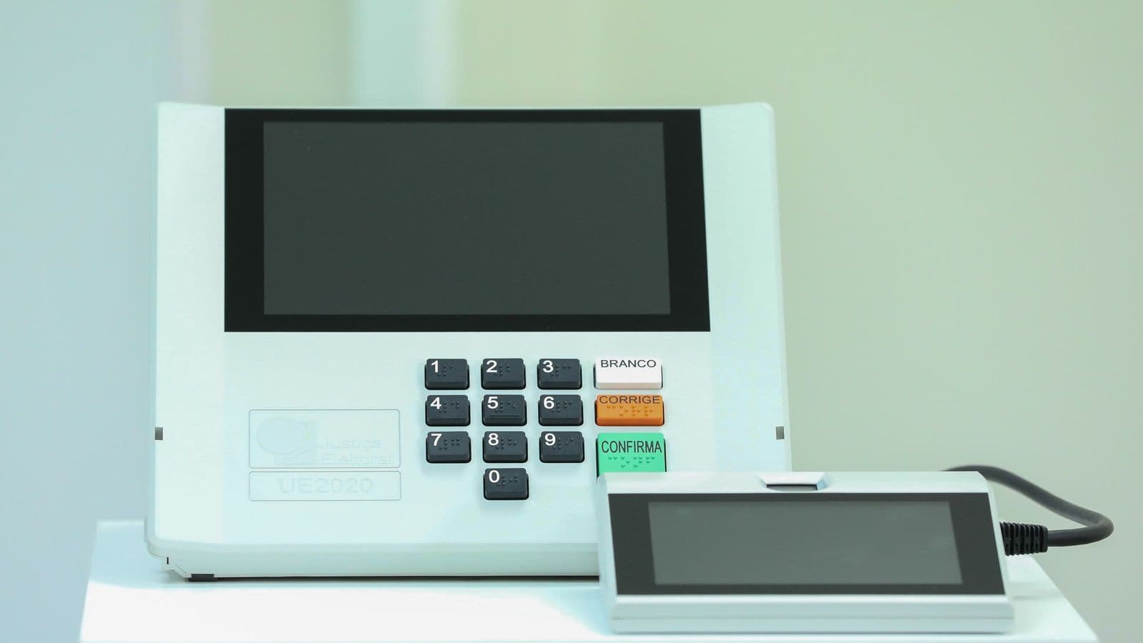 Urna eletrônica brasileira modelo UE2020, com teclado numérico e tela, sobre uma mesa branca